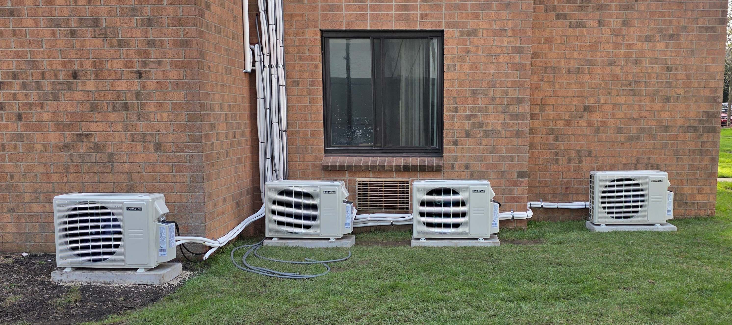 Multi-zone mini-split bank β four outdoor units along a brick exterior